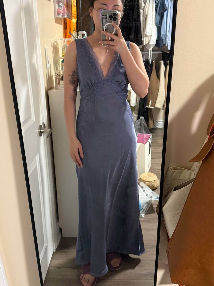 A person wearing a blue silk slip dress, a wonderful thrift store find.