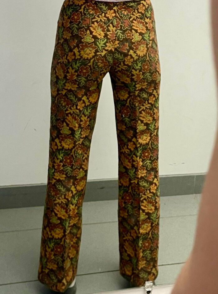A person wearing vintage floral pattern trousers, a great thrift store find.
