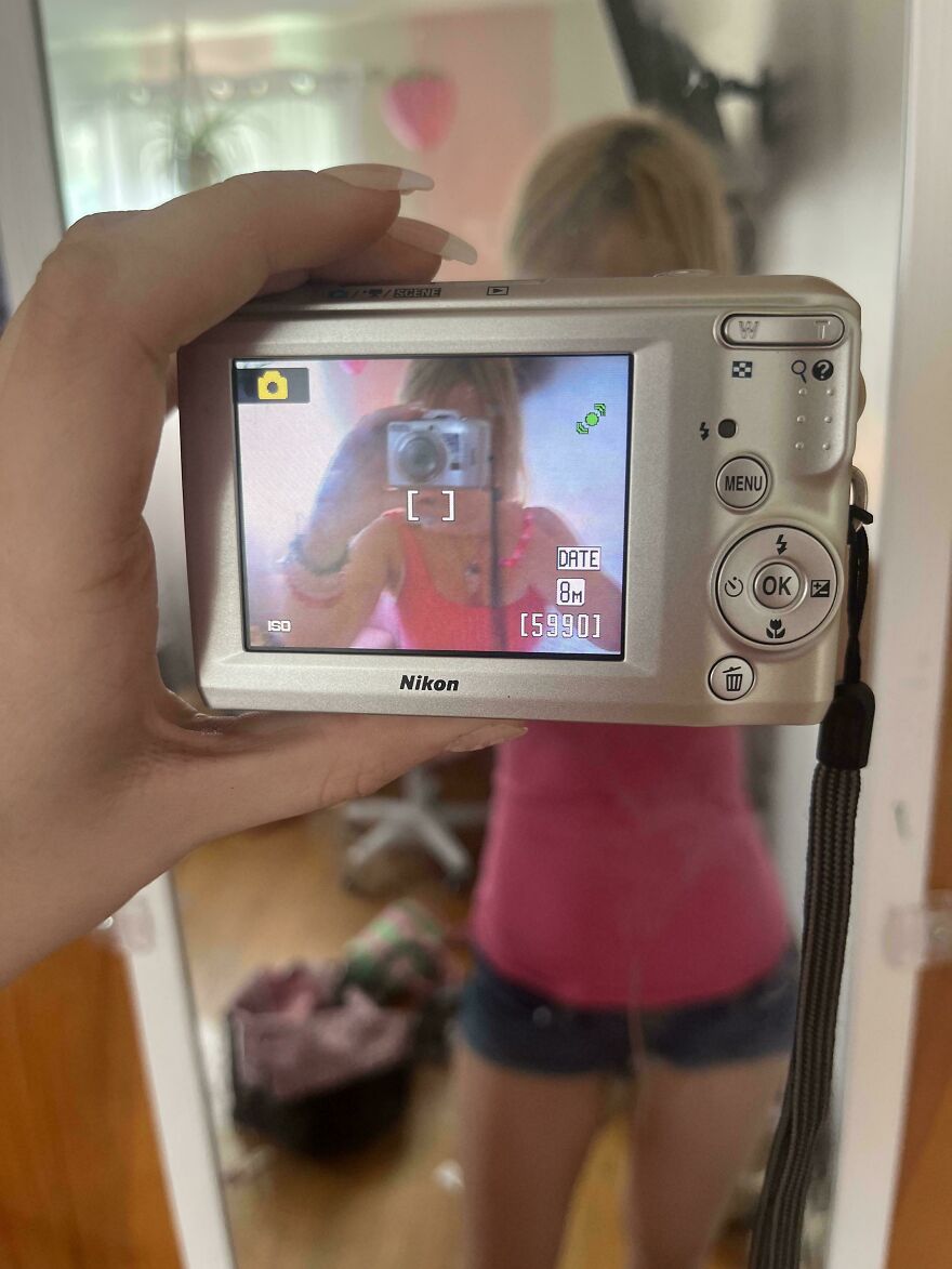 Nostalgic pics showing a girl taking a mirror selfie using a silver Nikon digital camera