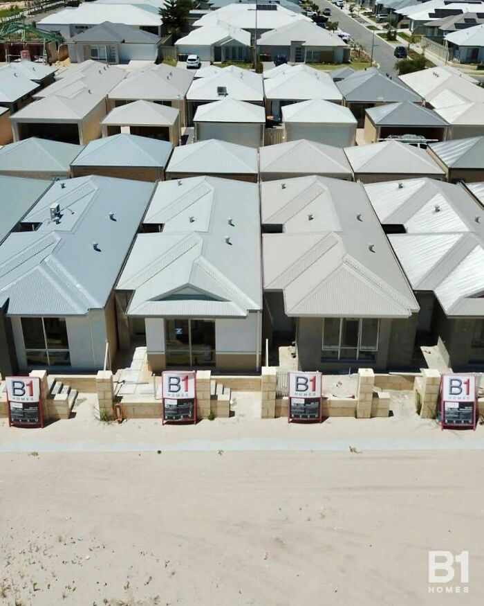 Aerial view of highly identical houses highlighting a modern suburban renting and booking estate development.