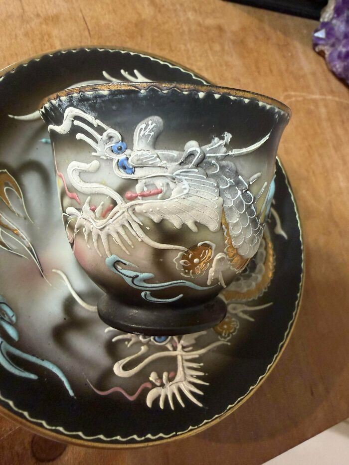 An ornate antique ceramic teacup featuring a raised dragon motif, a unique old treasure discovered by antique lovers.