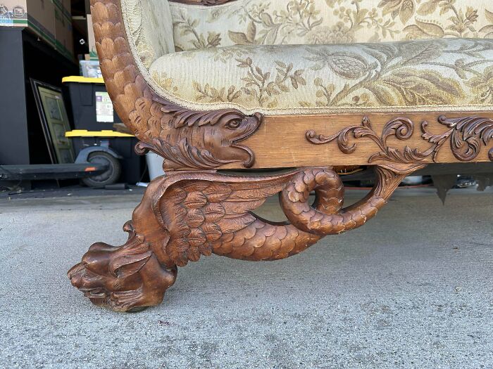 Detailed ornate carved wood leg of an antique sofa, showcasing old treasures.