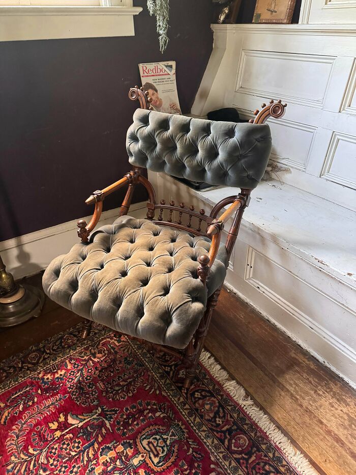 Vintage tufted armchair placed on an ornate rug displaying old treasures discovered by antique lovers.