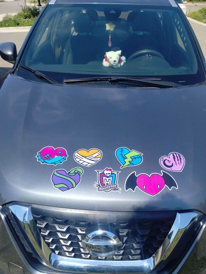 Monster High themed decals on a grey car hood, showcasing wild bumper stickers and stickers.