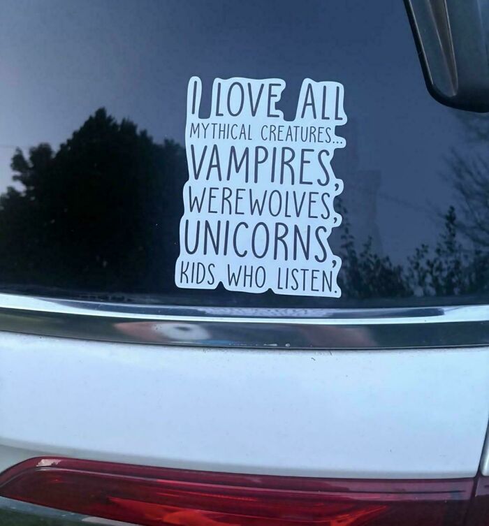 Funny bumper stickers about loving mythical creatures like kids who listen, placed on a car window.