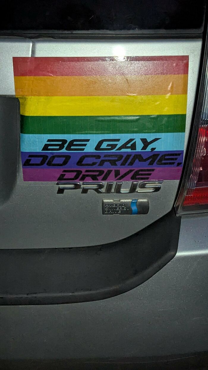 Rainbow pride bumper stickers combined with car emblem reading BE GAY, DO CRIME, DRIVE PRIUS