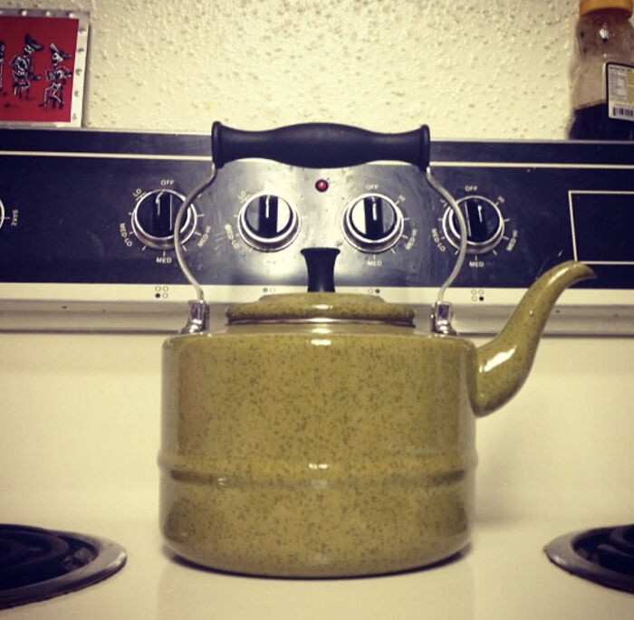Teapot on stove knobs creating face illusion with eye confusing effect