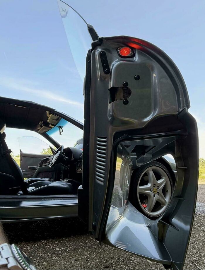 Car door open with wheel visible inside door panel showing unique car feature