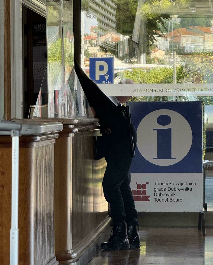 Optical illusion of person bending behind glass at Dubrovnik tourist board