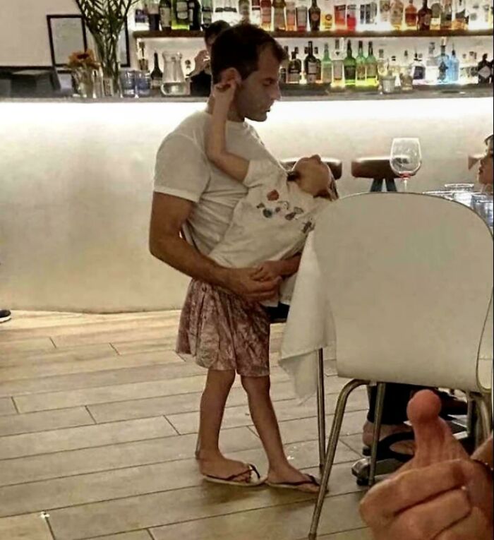 Man holding child looks like child wearing adult skirt due to optical illusion