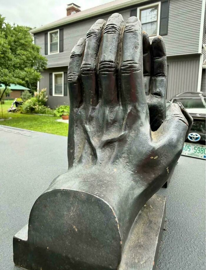 Sculpture of a giant hand creating a confusing visual illusion