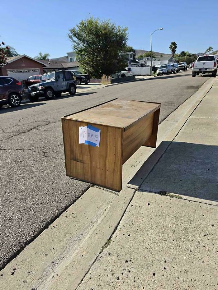 Desk positioned on curb casting a shadow that confuses the eye