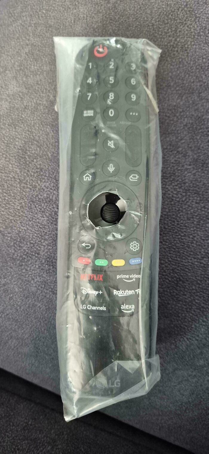 A brand new TV remote control still wrapped in its protective plastic cover