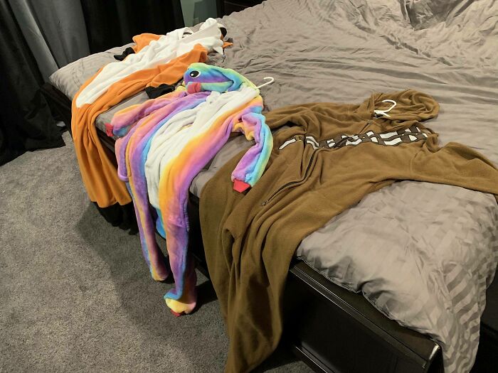Colorful animal onesies laid out on a bed, showcasing some cute or unhinged things wives do