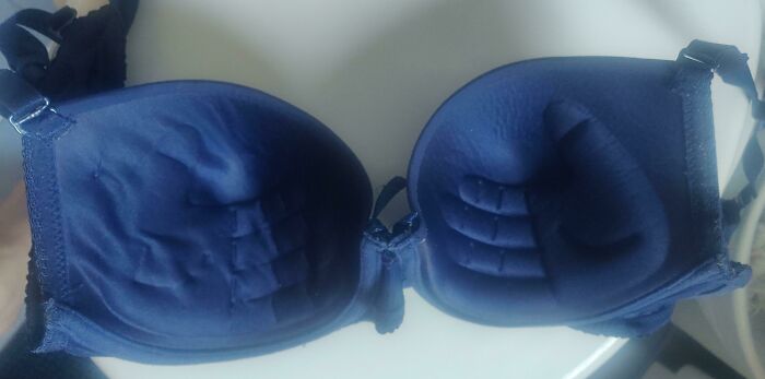 The inside of a blue bra designed with hand-shaped padding, showing funny things wives do