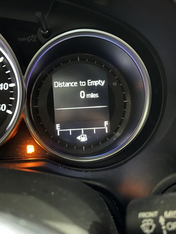 A car dashboard showing zero miles to empty, a funny example of ridiculous things wives do.