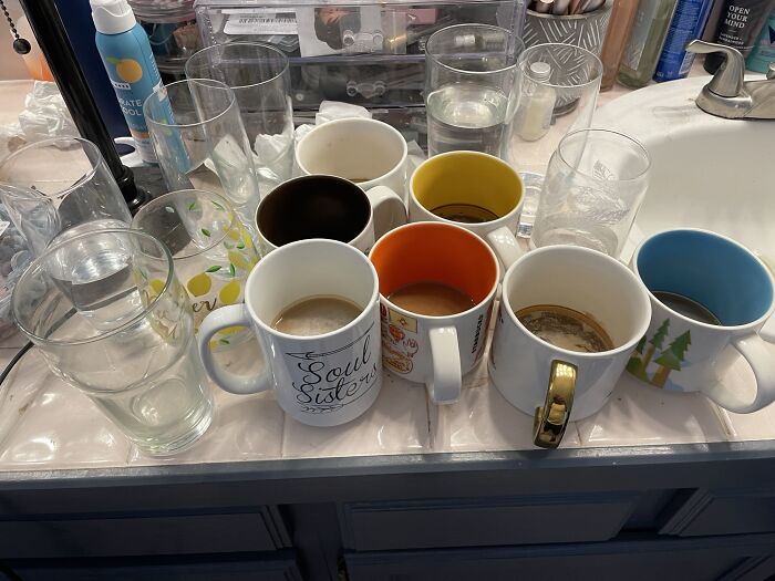 Collection of dirty glasses and coffee mugs on a bathroom counter, highlighting cute things wives do