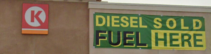 A gas station banner reading DIESEL SOLD FUEL HERE, showcasing a badly designed sign.