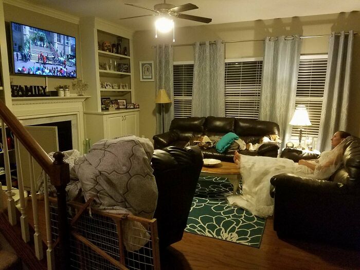A woman wearing a wedding dress relaxes on a living room sofa, showing cute things wives do