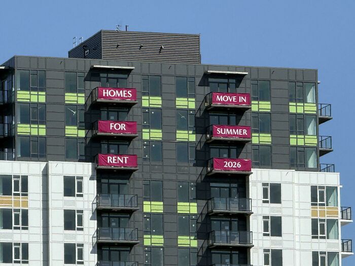 Apartment building balconies displaying promotional banners with confusing order, an example of badly designed signs.