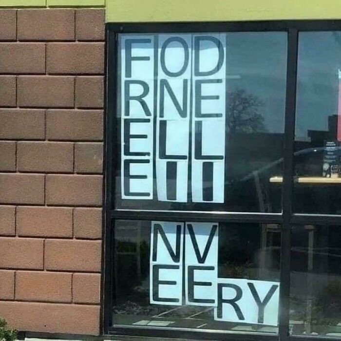 Confusing window sign with misplaced letters showcasing a badly designed sign.