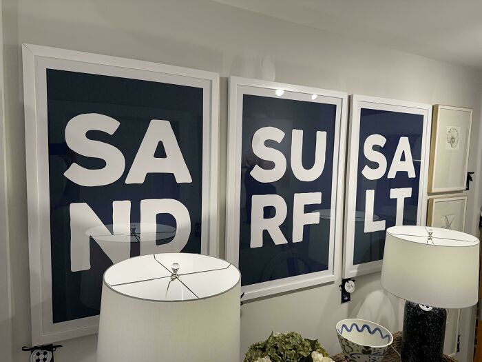 Framed wall art prints displaying badly designed signs with poorly formatted letters spelling sand, surf, and salt.