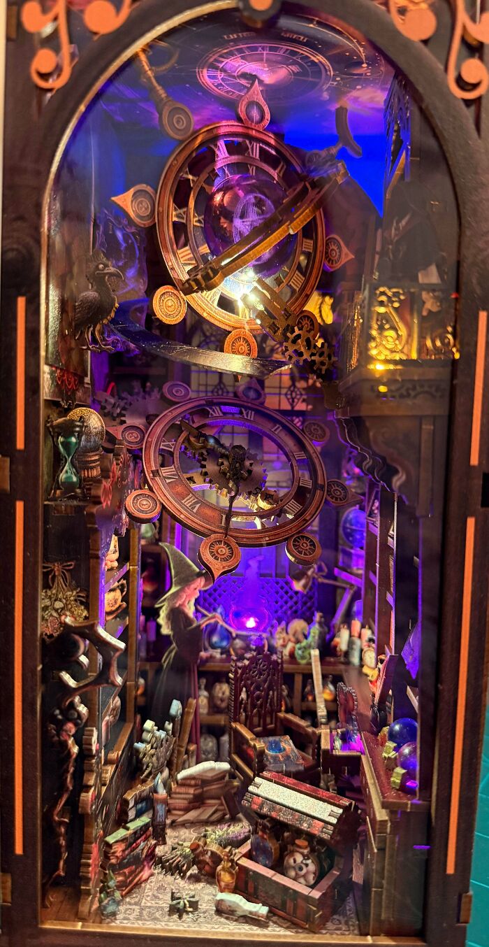 A magical wizard book nook showing a witch casting spells among books and illuminated clock gears.