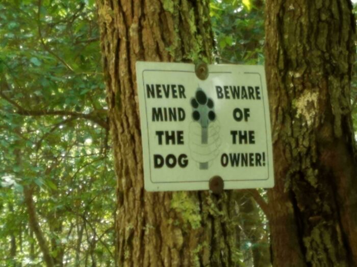 Warning sign on a tree with confusing layout, an example of hilarious badly designed signs in nature.