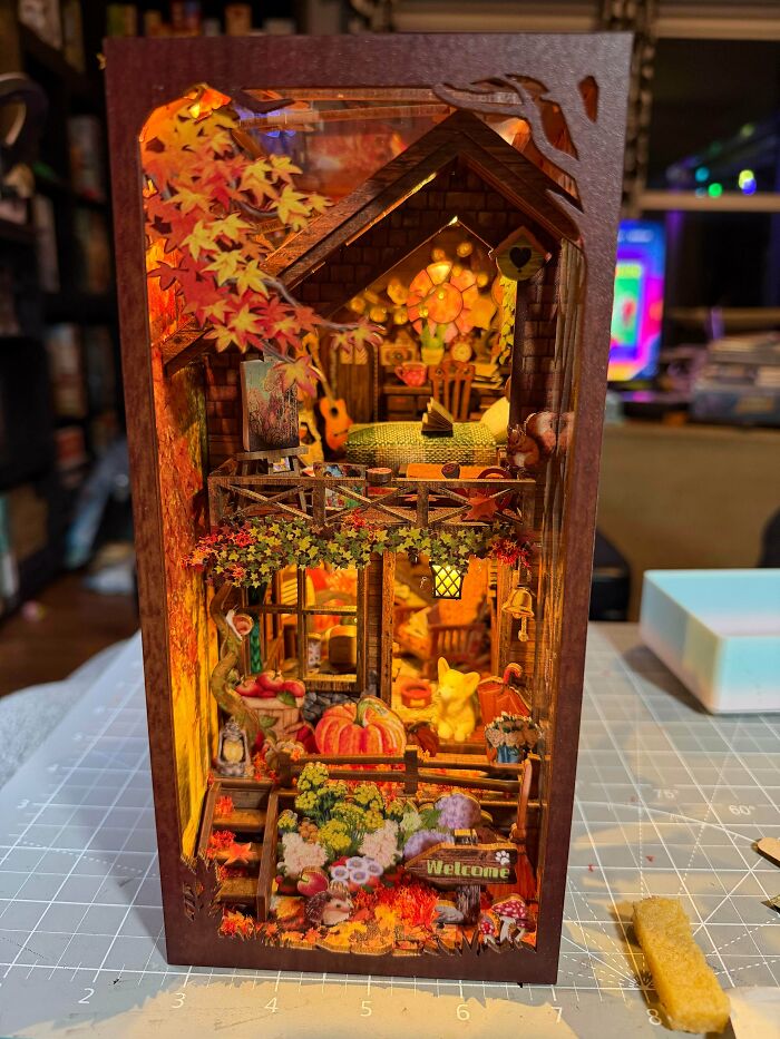 A warm autumn themed book nooks insert displaying a miniature treehouse filled with pumpkins