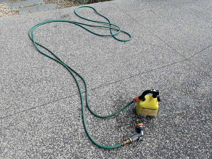 A green garden hose connected incorrectly on both ends, highlighting funny things wives do.