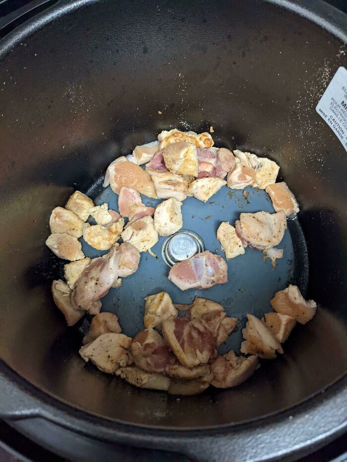 Diced chicken pieces cooking inside an air fryer basket, showing funny things wives do