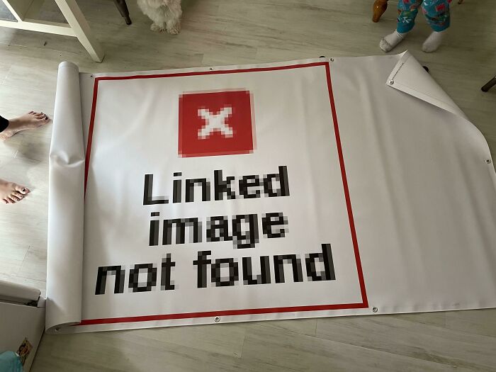A printed banner displaying Linked image not found laid out on the floor.