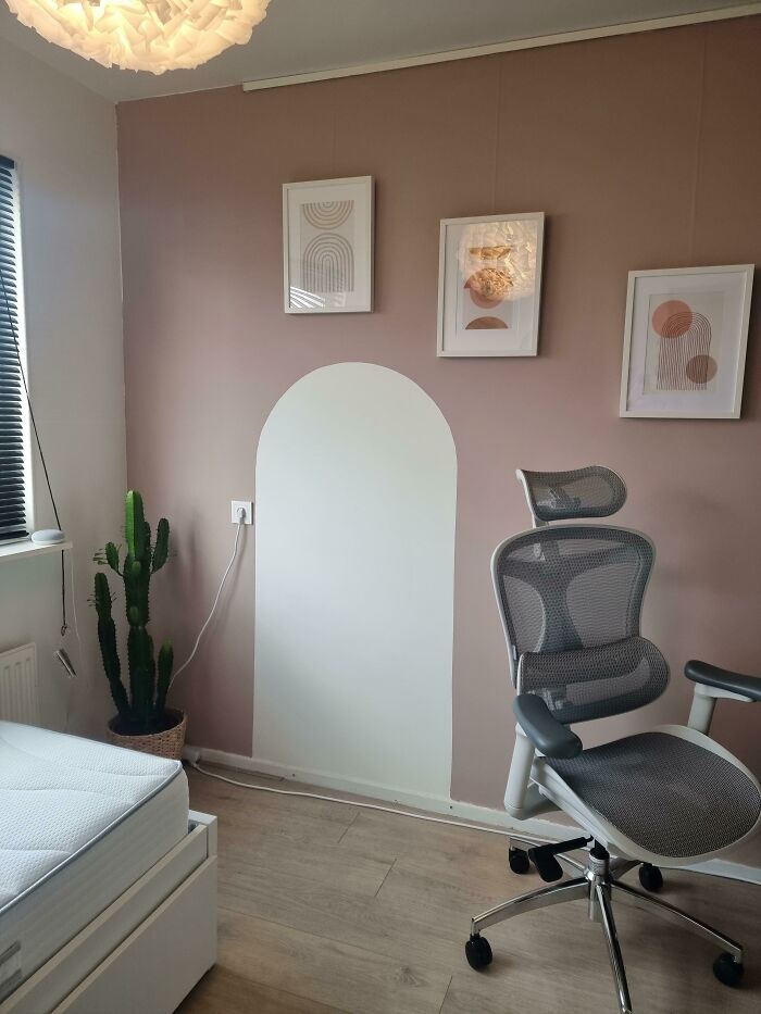 An office room with a painted white arch on a dusty pink wall, showcasing things wives do.