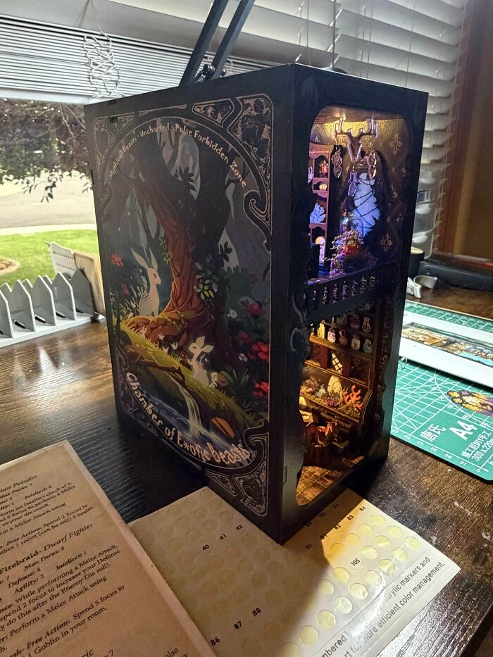 A dark fantasy book nook depicting the Chamber of Exotic Beasts with intricate illustrations and lights.
