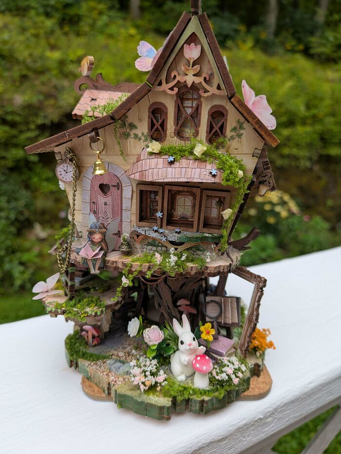 A whimsical fairy-tale treehouse book nook with a tiny rabbit and a fairy holding a book