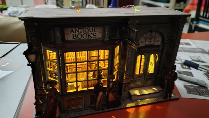 A glowing antique bookshop facade model built as a creative book nook art piece.