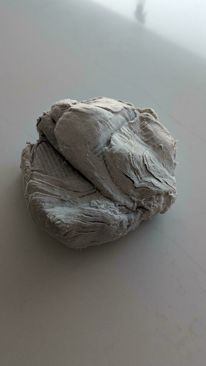 A hard, compressed gray mass of toilet paper illustrating husbands venting about wives.