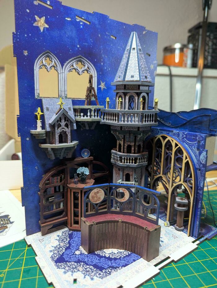 A detailed book nook miniature of an astronomical observatory with a starry night sky backdrop.