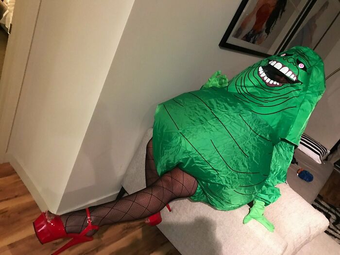 A wife in a green Slimer costume posing funny, a cute thing husbands post