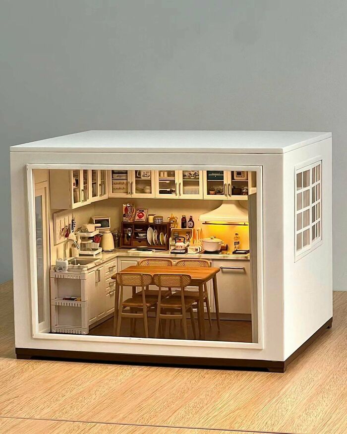 A modern miniature kitchen book nook with small dining table and overhead cabinets