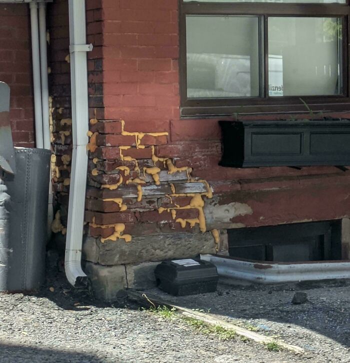 Cracked brick wall repaired with expanding foam representing questionable DIY projects.