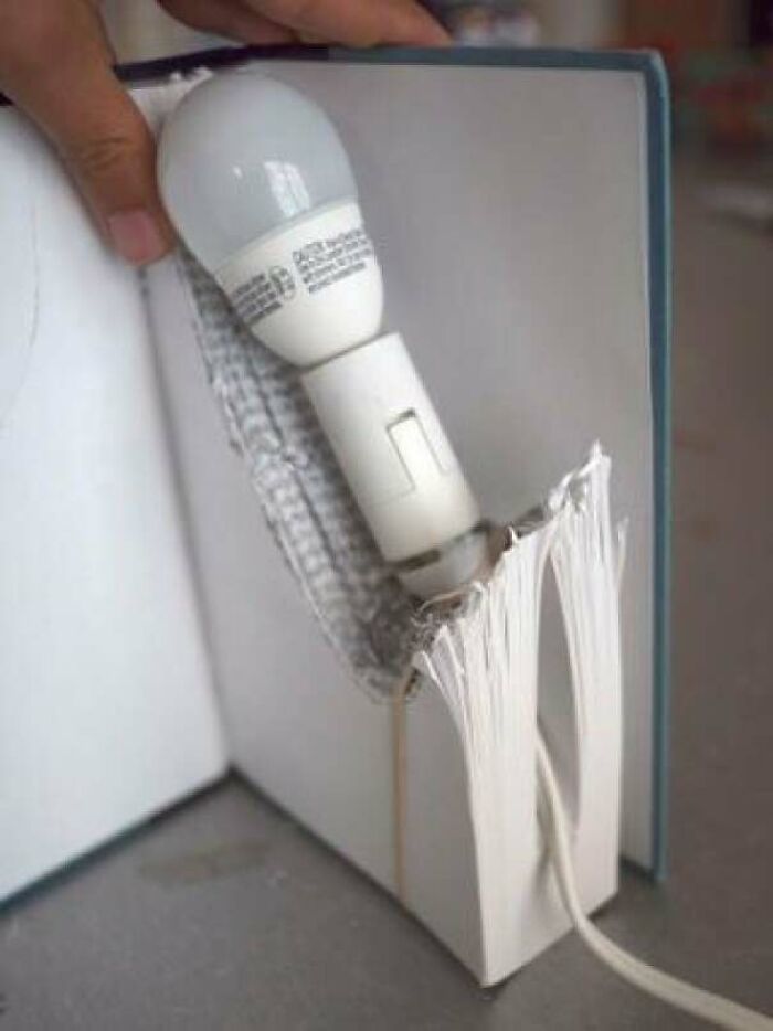 Light bulb wired into the pages of a carved book as a funny DIY project