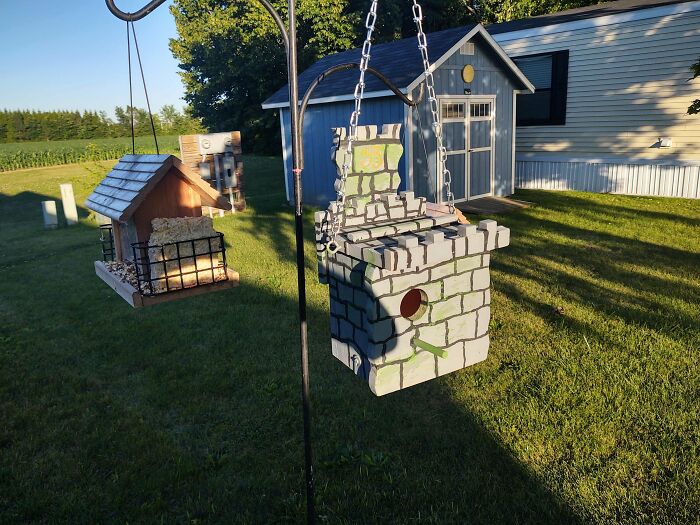 A castle-shaped birdhouse hanging outdoors as a unique addition to DIY projects.