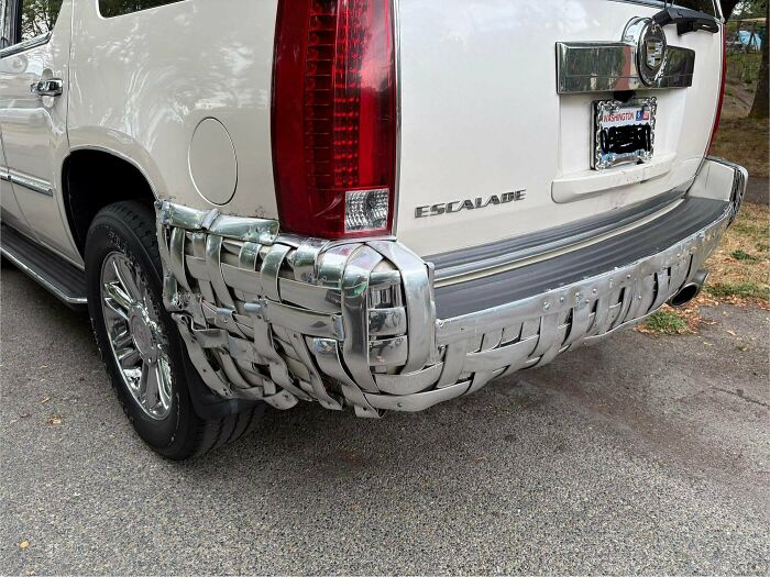 Rear bumper of a white SUV repaired with woven metal straps as one of many questionable DIY projects.