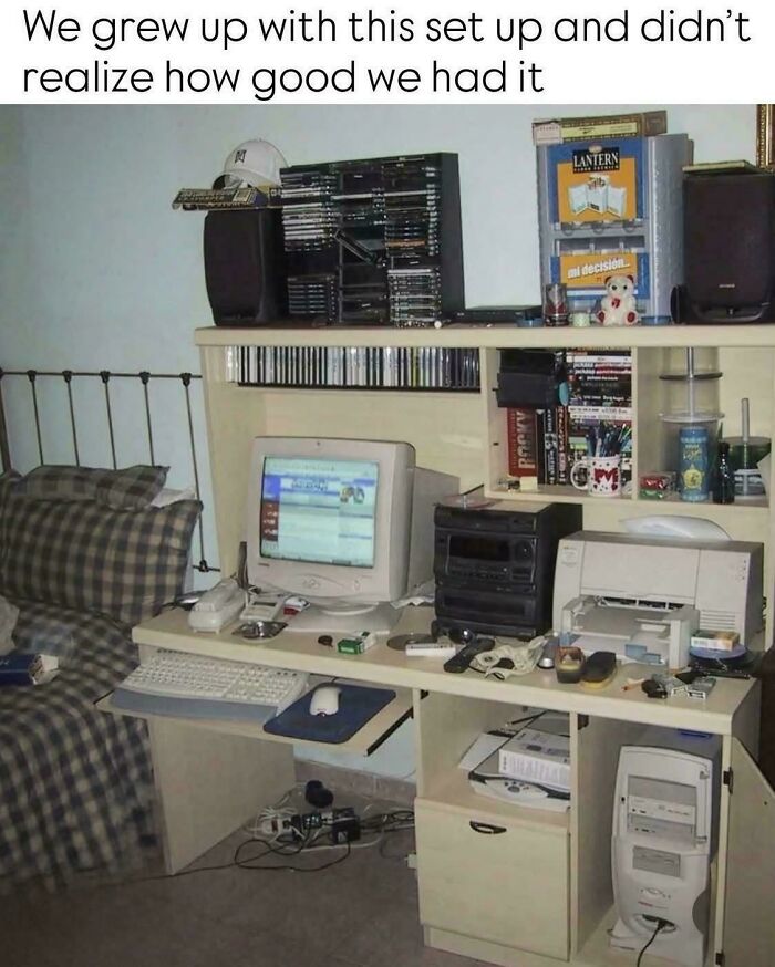 A classic '90s computer desk setup with a CRT monitor, tower, printer, and CD racks