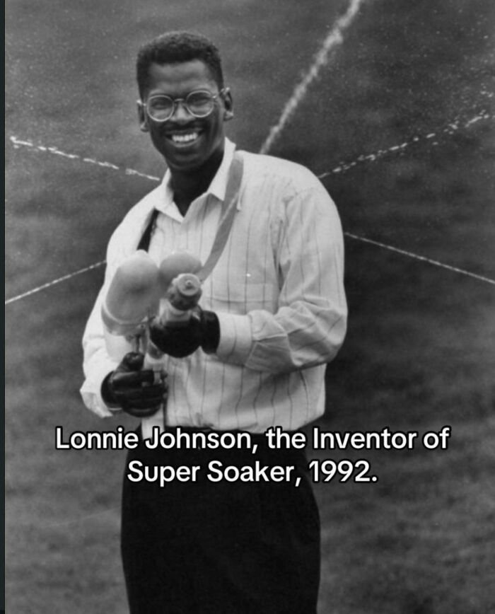 A black and white photo of Lonnie Johnson holding a Super Soaker, an iconic toy from the 90s.