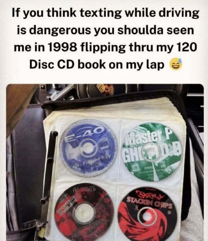 A 90s CD organizer book open in a car showing music discs to help remember the carefree days