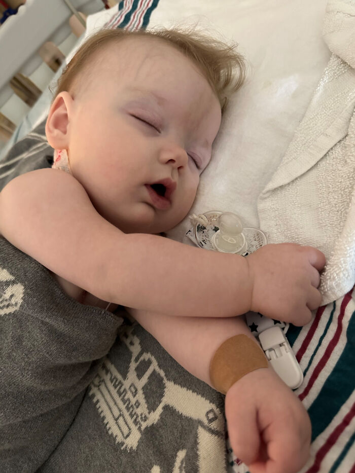 A peaceful baby sleeping soundly with a pacifier, featured in wholesome pics of dads capturing sweet moments.