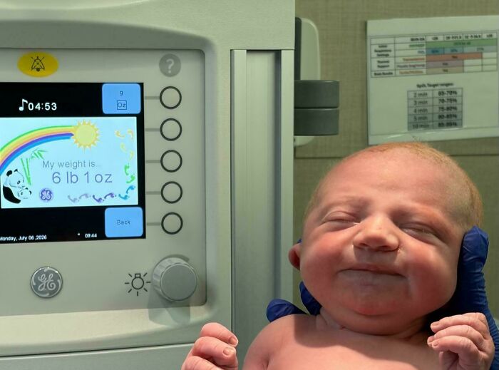 A newborn baby resting peacefully on a medical scale, included in wholesome pics of dads celebrating new life.