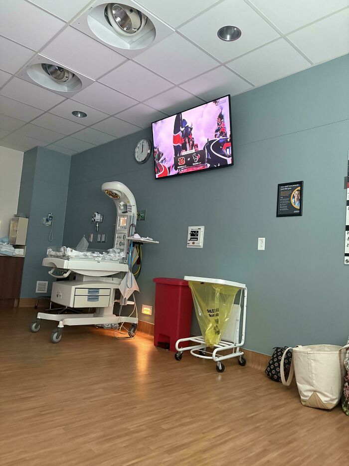 A delivery room TV showing a game as a dad prepares for fatherhood with wholesome anticipation